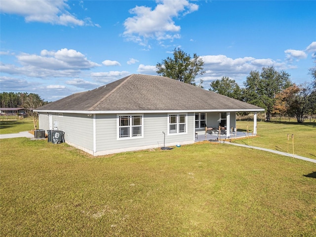 back of house with a patio, central air condition unit, and a yard