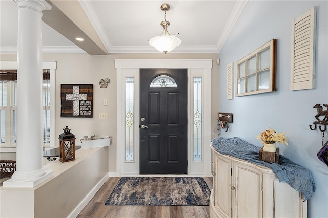 foyer with dark wood-type flooring, crown molding, and ornate columns