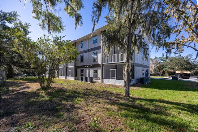 back of property with a lawn and central air condition unit