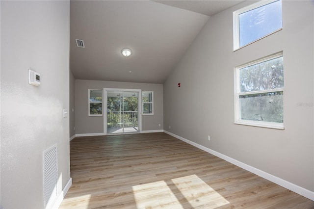 empty room with light hardwood / wood-style flooring and vaulted ceiling