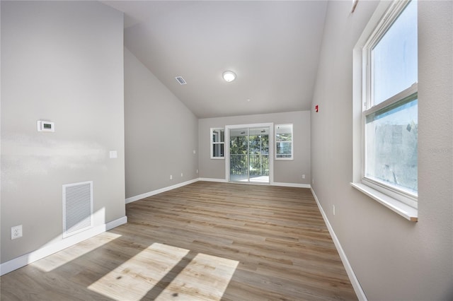 unfurnished room featuring light wood-type flooring, high vaulted ceiling, and plenty of natural light