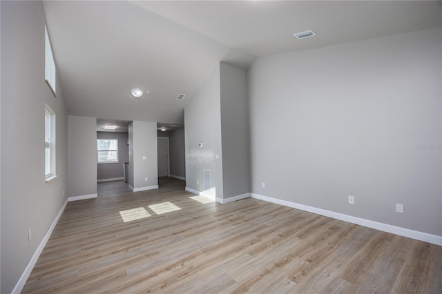 unfurnished living room with light hardwood / wood-style floors and vaulted ceiling