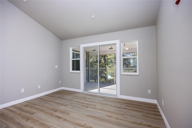 unfurnished room featuring light hardwood / wood-style flooring and lofted ceiling