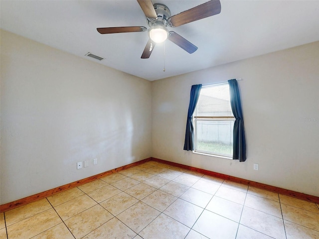 tiled spare room featuring ceiling fan