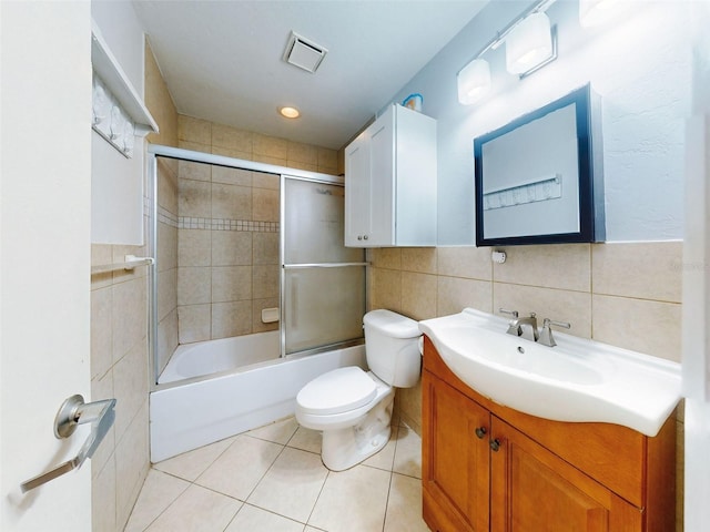 full bathroom with vanity, tile patterned floors, toilet, enclosed tub / shower combo, and tile walls