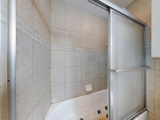 bathroom featuring bath / shower combo with glass door