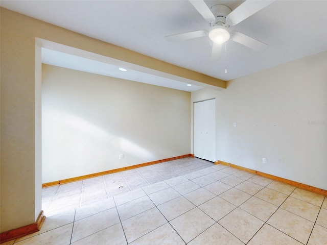 tiled spare room featuring ceiling fan