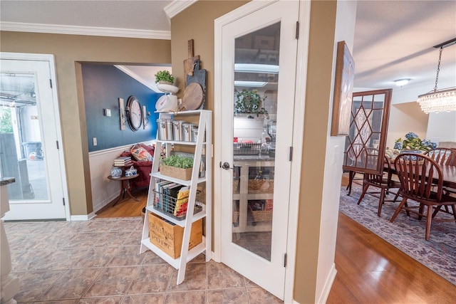 entryway featuring wood-type flooring, crown molding, and an inviting chandelier