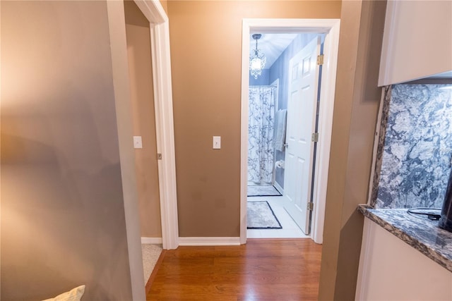 doorway to outside featuring a notable chandelier and wood-type flooring