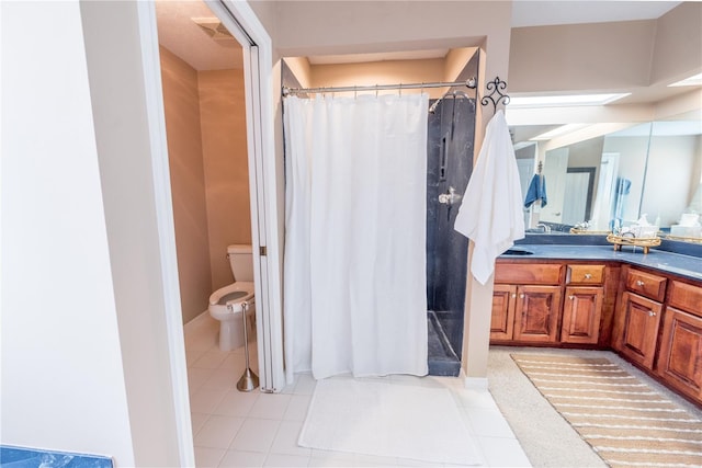 bathroom featuring tile patterned floors, vanity, toilet, and curtained shower