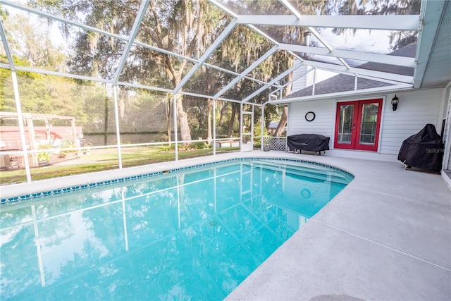 view of swimming pool with french doors, a patio, and glass enclosure