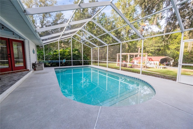 view of pool featuring glass enclosure and a patio area