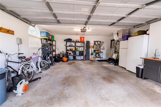 garage featuring white fridge and a garage door opener