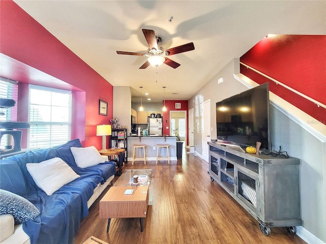 living room featuring wood-type flooring and ceiling fan