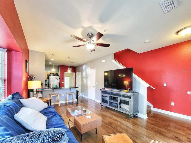 living room featuring ceiling fan, dark hardwood / wood-style flooring, and plenty of natural light