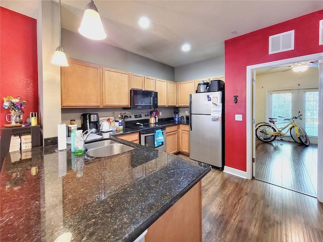 kitchen featuring appliances with stainless steel finishes, light brown cabinetry, sink, decorative light fixtures, and dark hardwood / wood-style floors