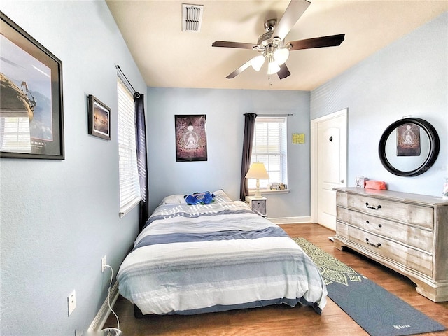 bedroom with dark hardwood / wood-style flooring and ceiling fan