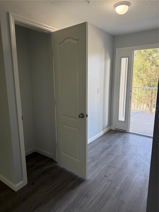 entryway with a textured ceiling and dark wood-type flooring