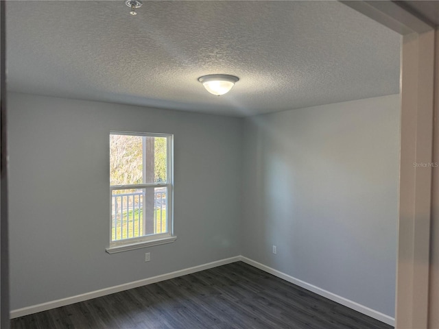 unfurnished room featuring a textured ceiling and dark hardwood / wood-style floors