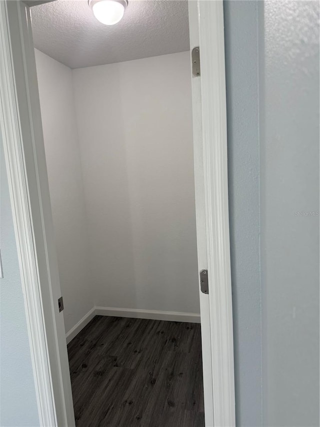 spare room with a textured ceiling and dark hardwood / wood-style floors