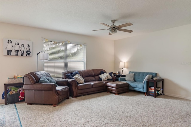 carpeted living room featuring ceiling fan and a textured ceiling