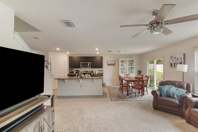 carpeted living room featuring ceiling fan