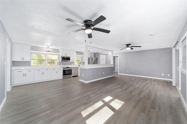 unfurnished living room with ceiling fan with notable chandelier, sink, wood-type flooring, and a textured ceiling