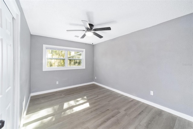 spare room featuring ceiling fan and dark hardwood / wood-style flooring