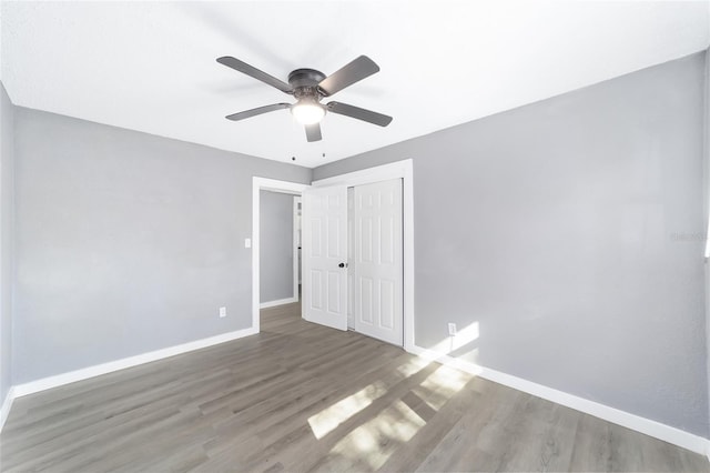 unfurnished bedroom with hardwood / wood-style floors, ceiling fan, and a closet