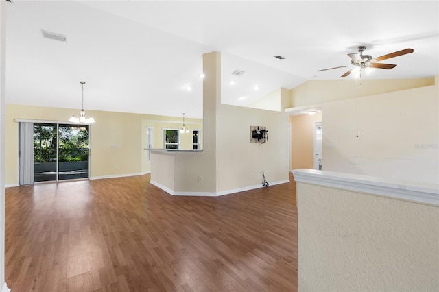 unfurnished living room with hardwood / wood-style floors, ceiling fan with notable chandelier, and lofted ceiling