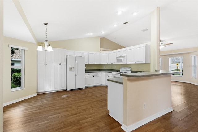 kitchen with white appliances, white cabinets, vaulted ceiling, dark hardwood / wood-style flooring, and kitchen peninsula