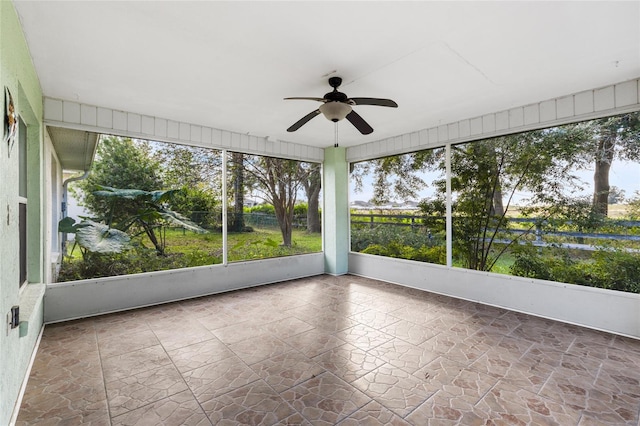 unfurnished sunroom with ceiling fan