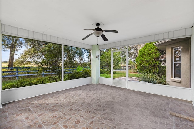 unfurnished sunroom featuring ceiling fan