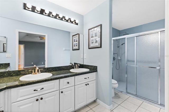 bathroom with tile patterned flooring, vanity, toilet, and walk in shower