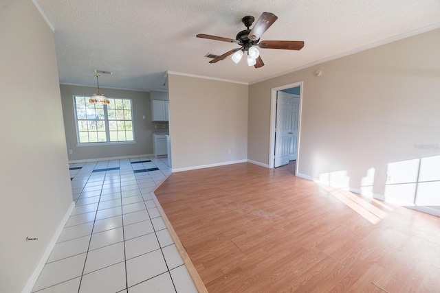 empty room with a textured ceiling, ceiling fan, light wood-type flooring, and crown molding