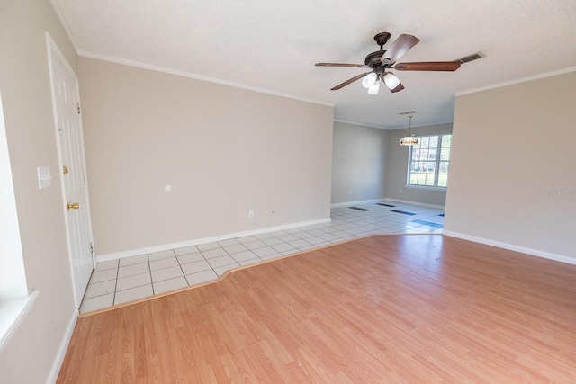 empty room with a textured ceiling, light hardwood / wood-style floors, ceiling fan, and ornamental molding