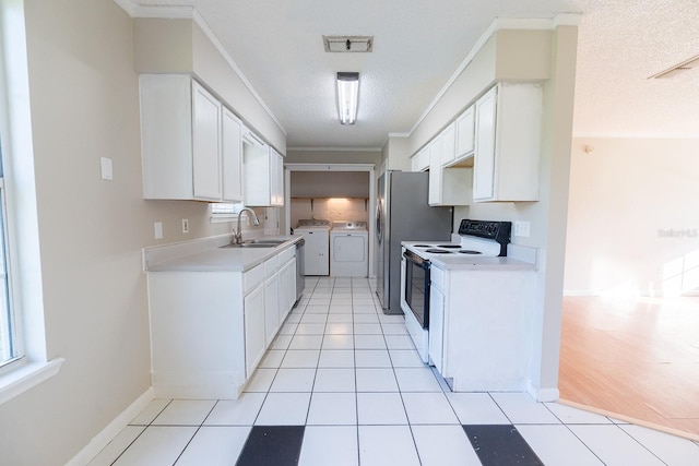 kitchen featuring white range with electric cooktop, white cabinets, independent washer and dryer, and sink