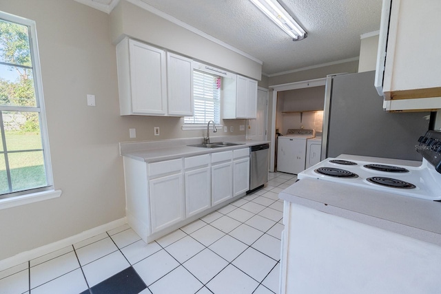 kitchen featuring white appliances, sink, ornamental molding, separate washer and dryer, and white cabinetry