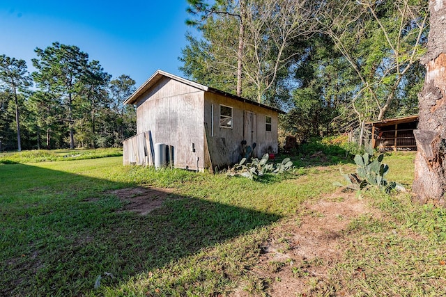 view of side of property with an outdoor structure and a lawn