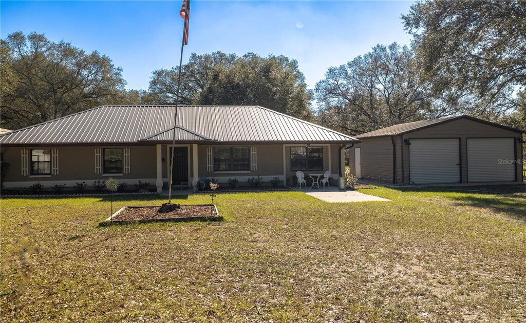 230 SW Charlie Ln, Lake City, FL 32024 - back of house featuring an outbuilding, a garage, and a lawn