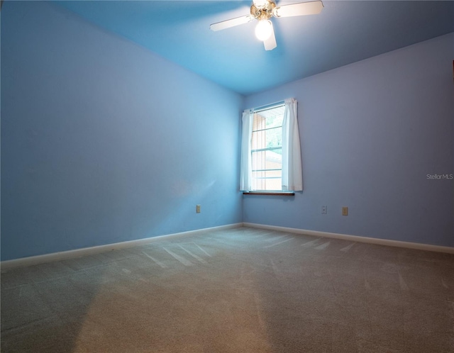 carpeted spare room with ceiling fan