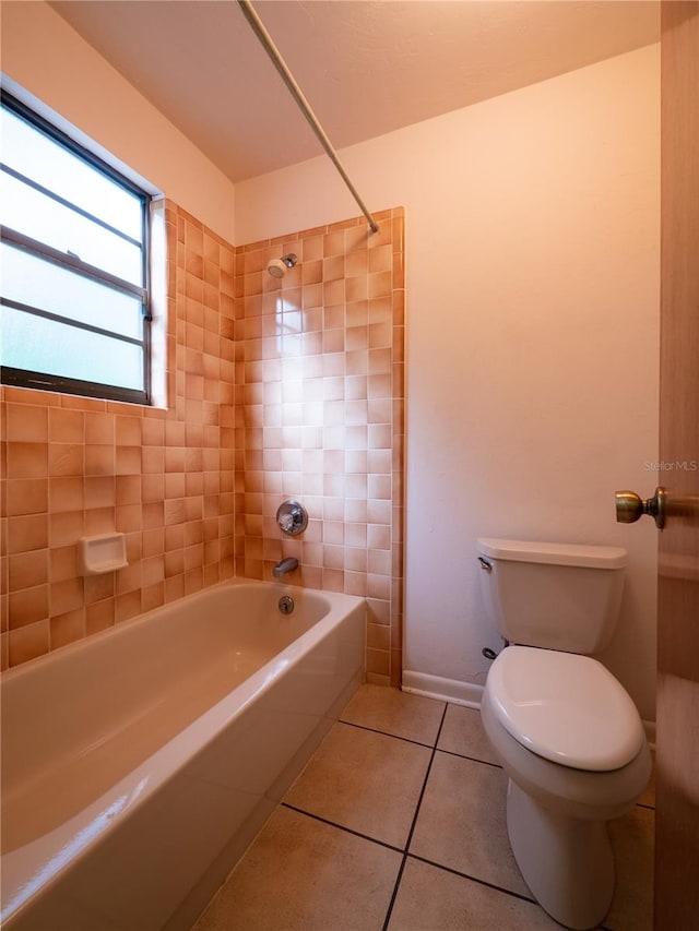 bathroom featuring tile patterned floors, tiled shower / bath combo, and toilet