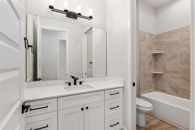 full bathroom featuring wood-type flooring, vanity, toilet, and tiled shower / bath combo