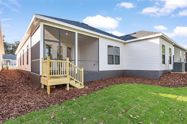 rear view of property featuring a yard and cooling unit