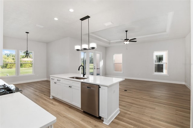 kitchen featuring sink, stainless steel dishwasher, light wood-type flooring, an island with sink, and plenty of natural light