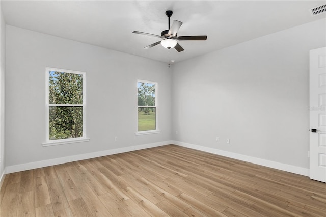 empty room featuring ceiling fan, plenty of natural light, and light hardwood / wood-style floors