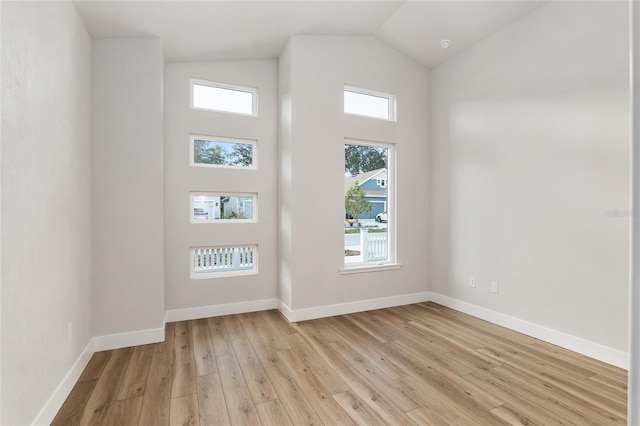 interior space with light wood-type flooring, vaulted ceiling, and a healthy amount of sunlight