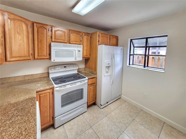 kitchen with light tile patterned flooring and white appliances