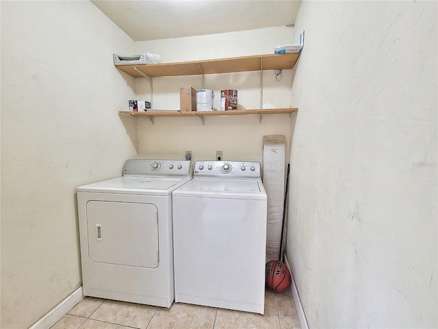 laundry room with light tile patterned floors and washing machine and clothes dryer