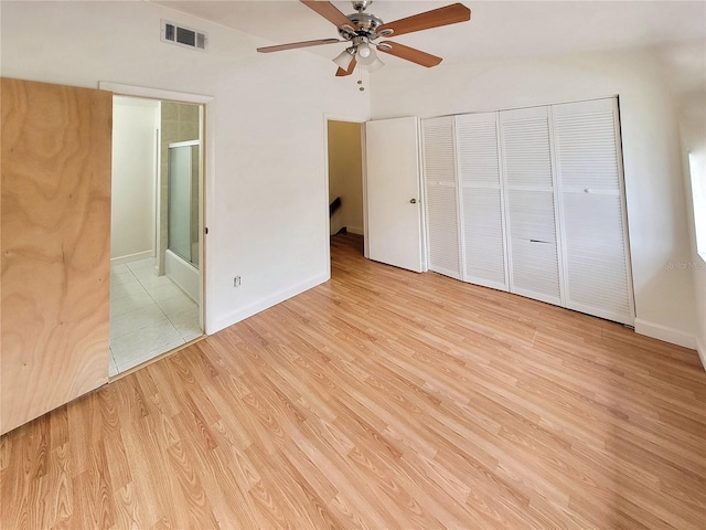 unfurnished bedroom featuring ceiling fan, light hardwood / wood-style floors, connected bathroom, and a closet